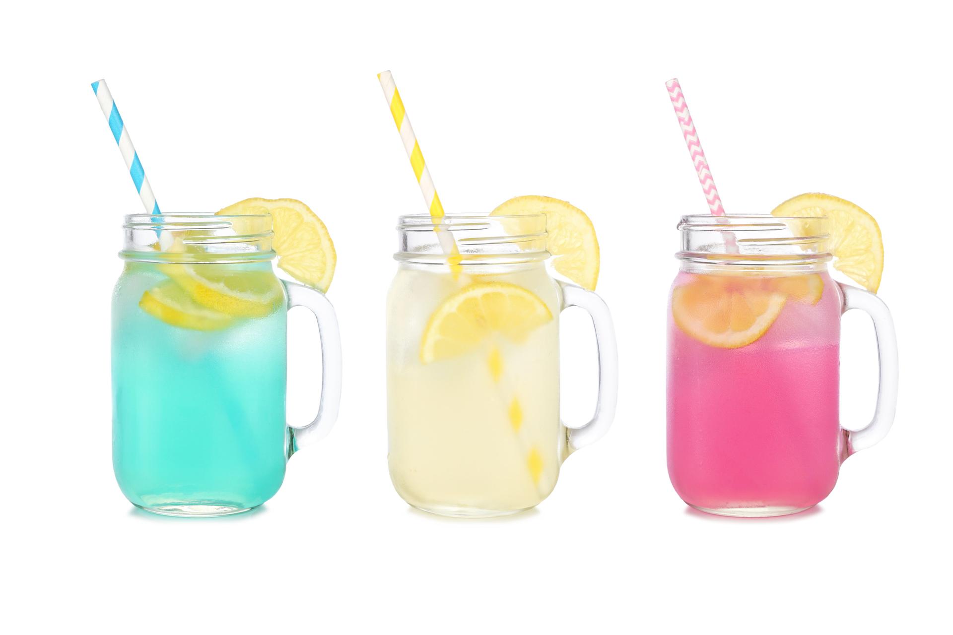 Colorful summer lemonade drinks in mason jar glasses isolated on white